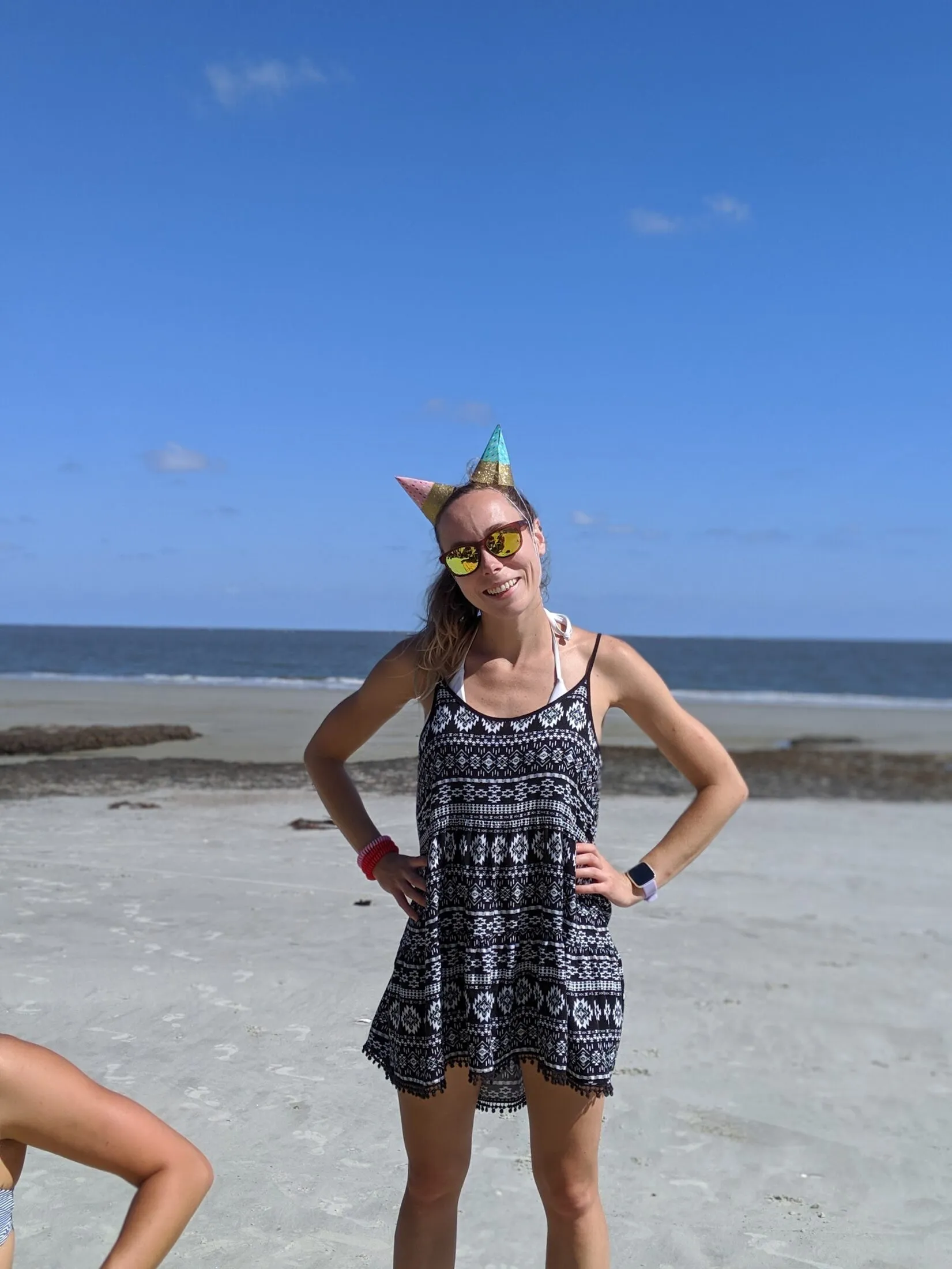 Holly with two party hats at the beach.