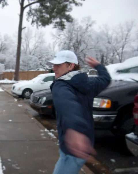 Spencer winds up to throw a snowball.