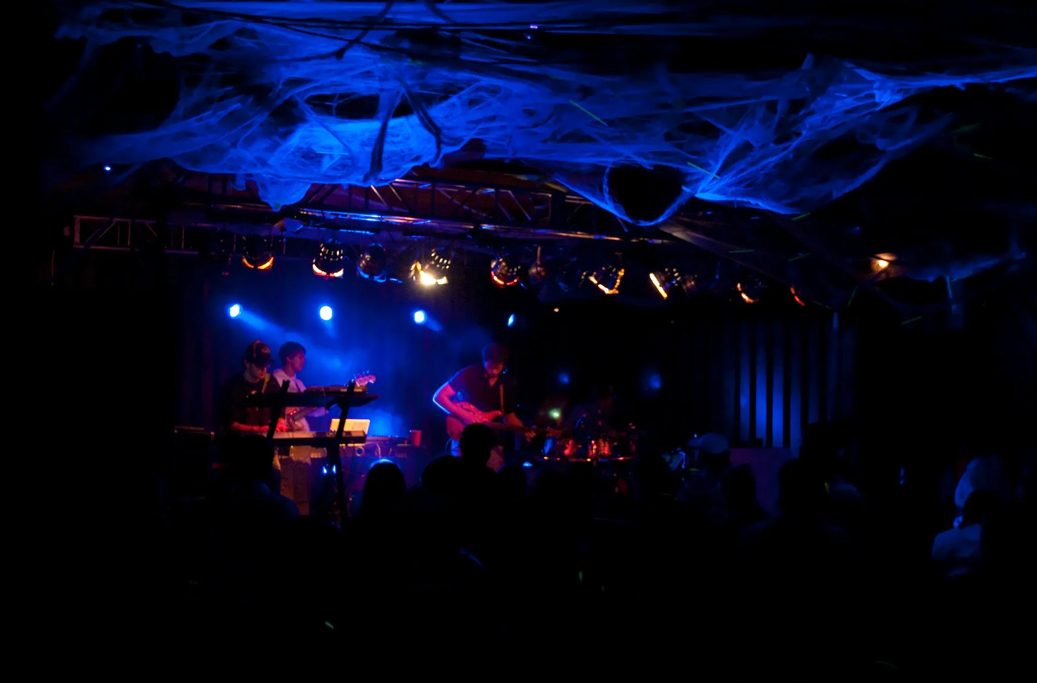 Dark blue lights as the band plays on stage.