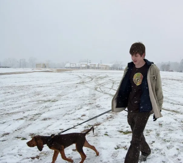 Luke walks his dog in the snow.