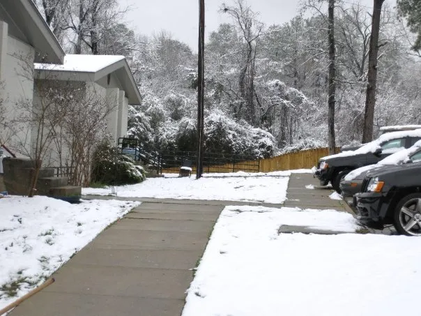 The walkway to the back of the fraternity house covered in snow.