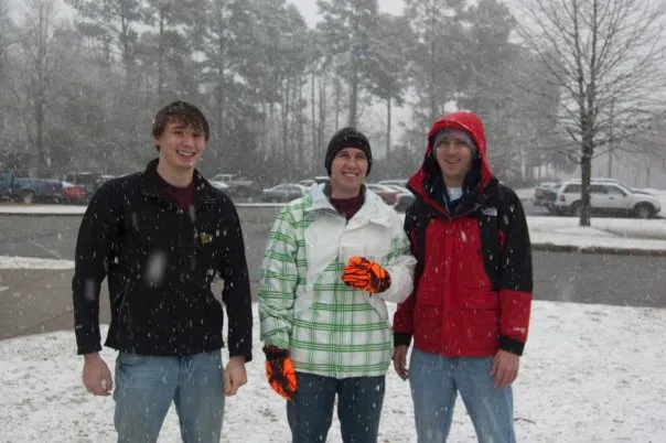 Three friends pose for a picture in the snow.