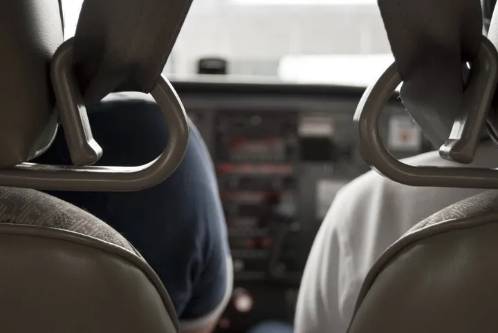View between two pilot seats facing the controls.