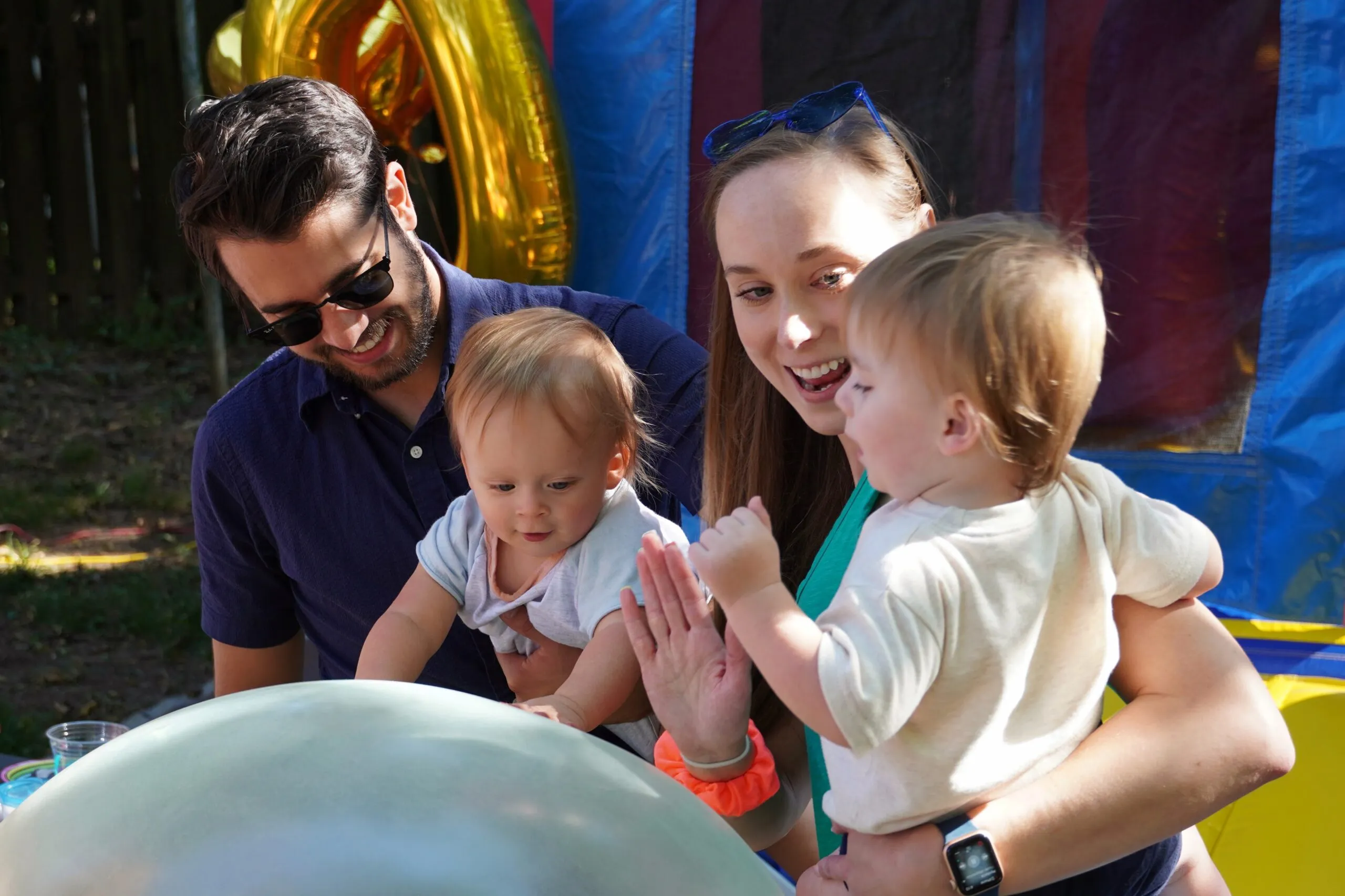 Babies playing with a large bouncy ball.