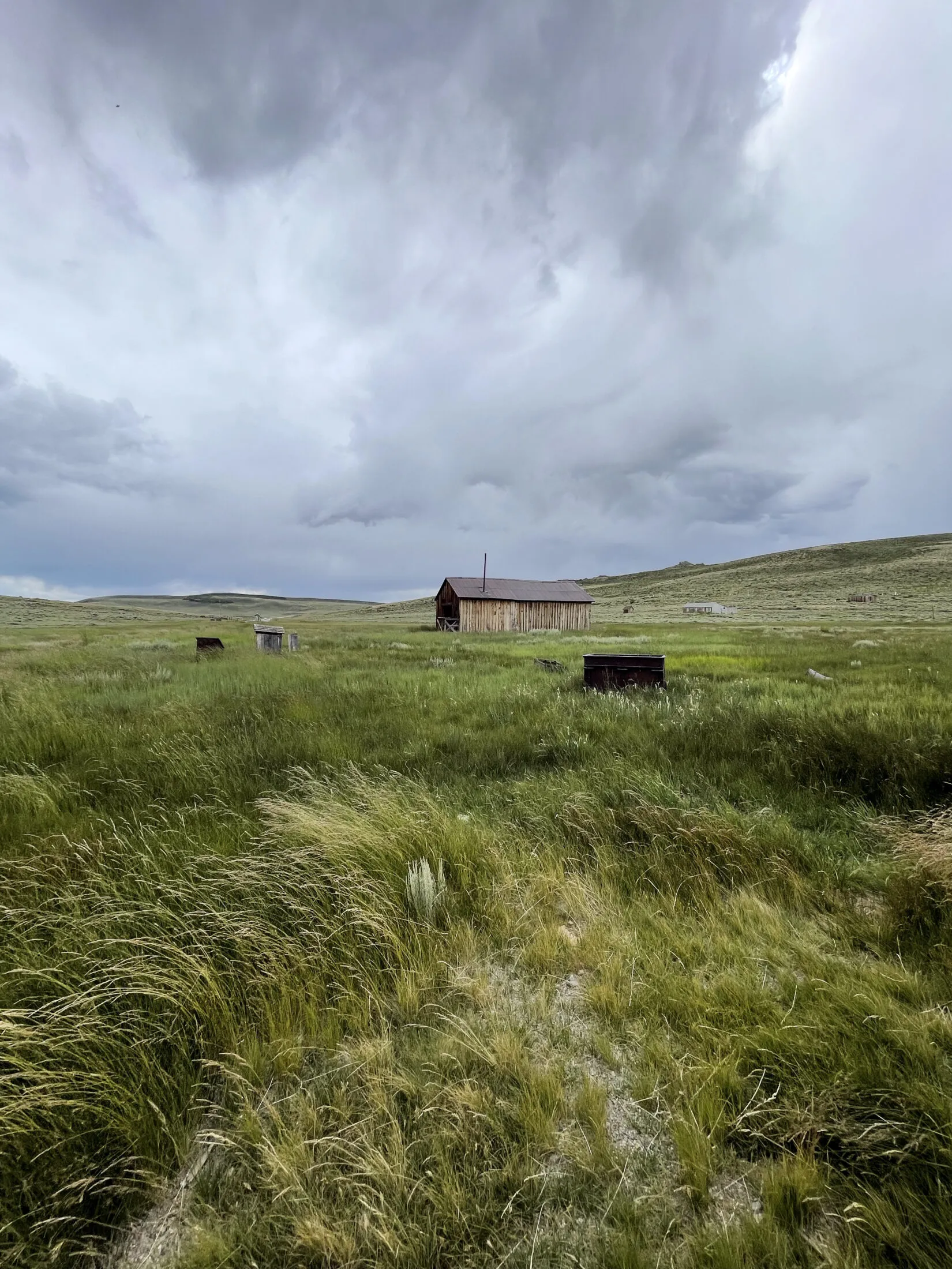 A field with some old barns and sheds in the distance.