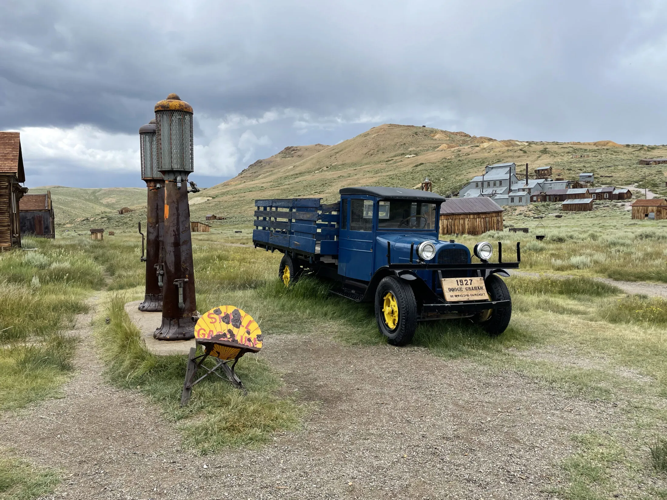 An old truck next to a gas pump.