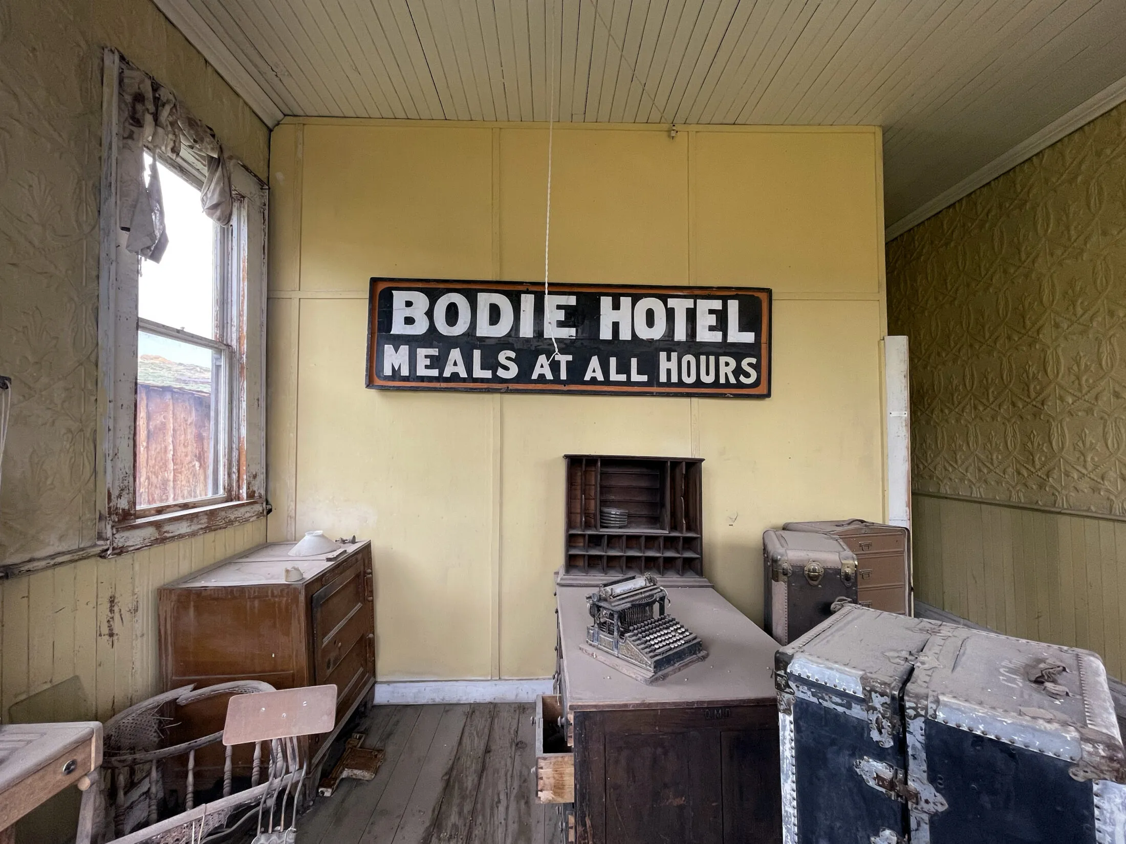 Front desk at the old Bodie Hotel. Has a sign that reads Bodie Hotel Meals at All Hours.