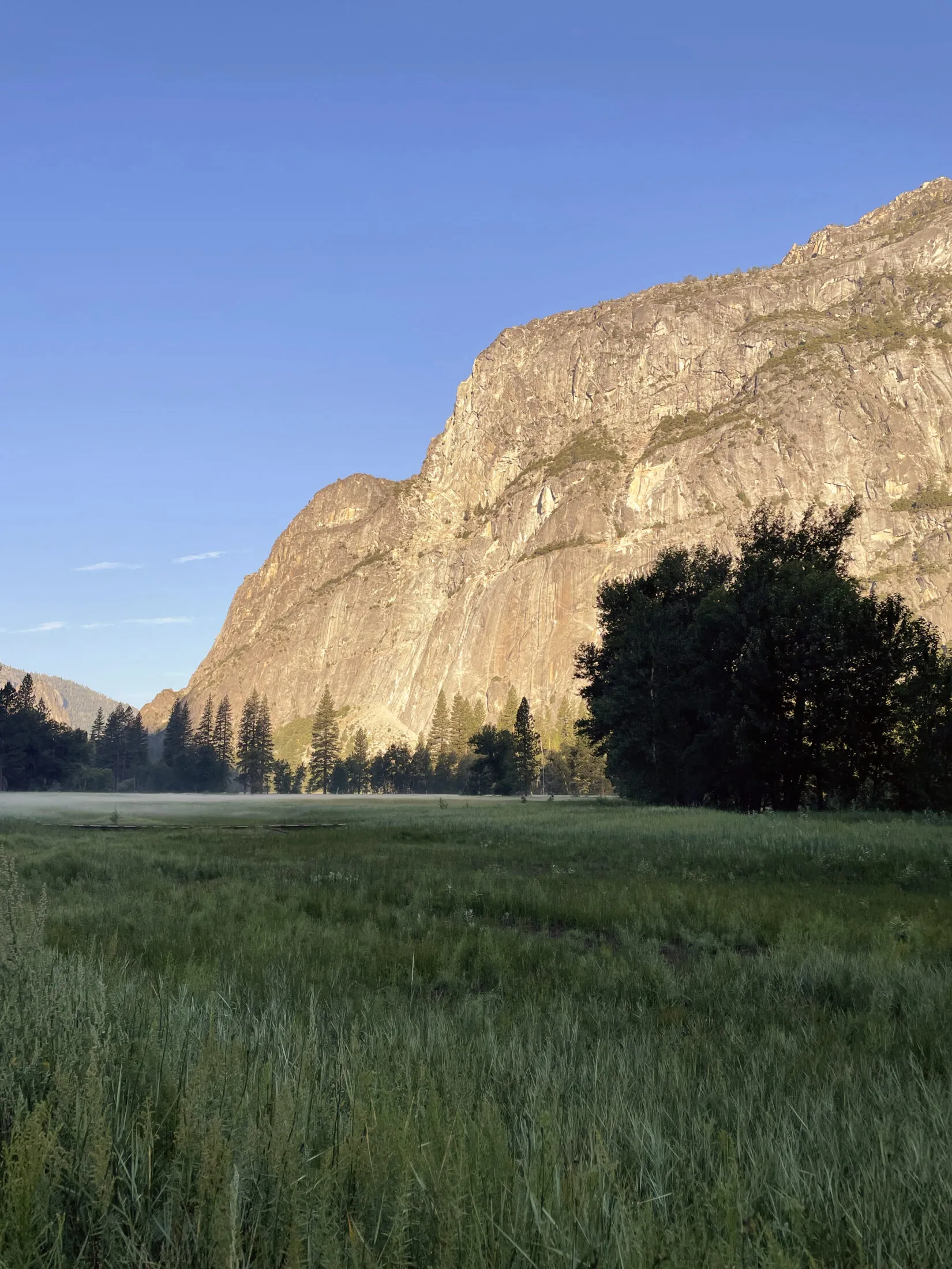 Light hits the face of a mountain.