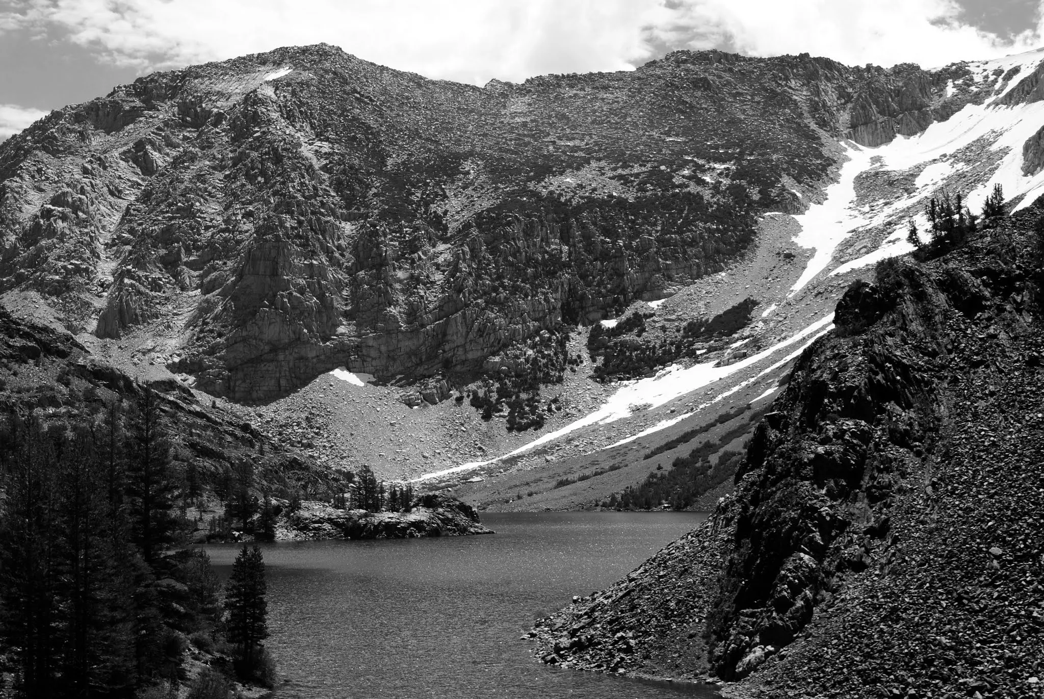 Black and white photo of a lake surrounded by mountains.